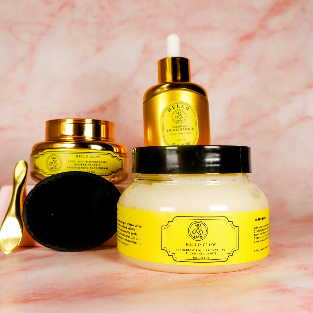 Skincare products with gold and yellow packaging on a pink marble background.